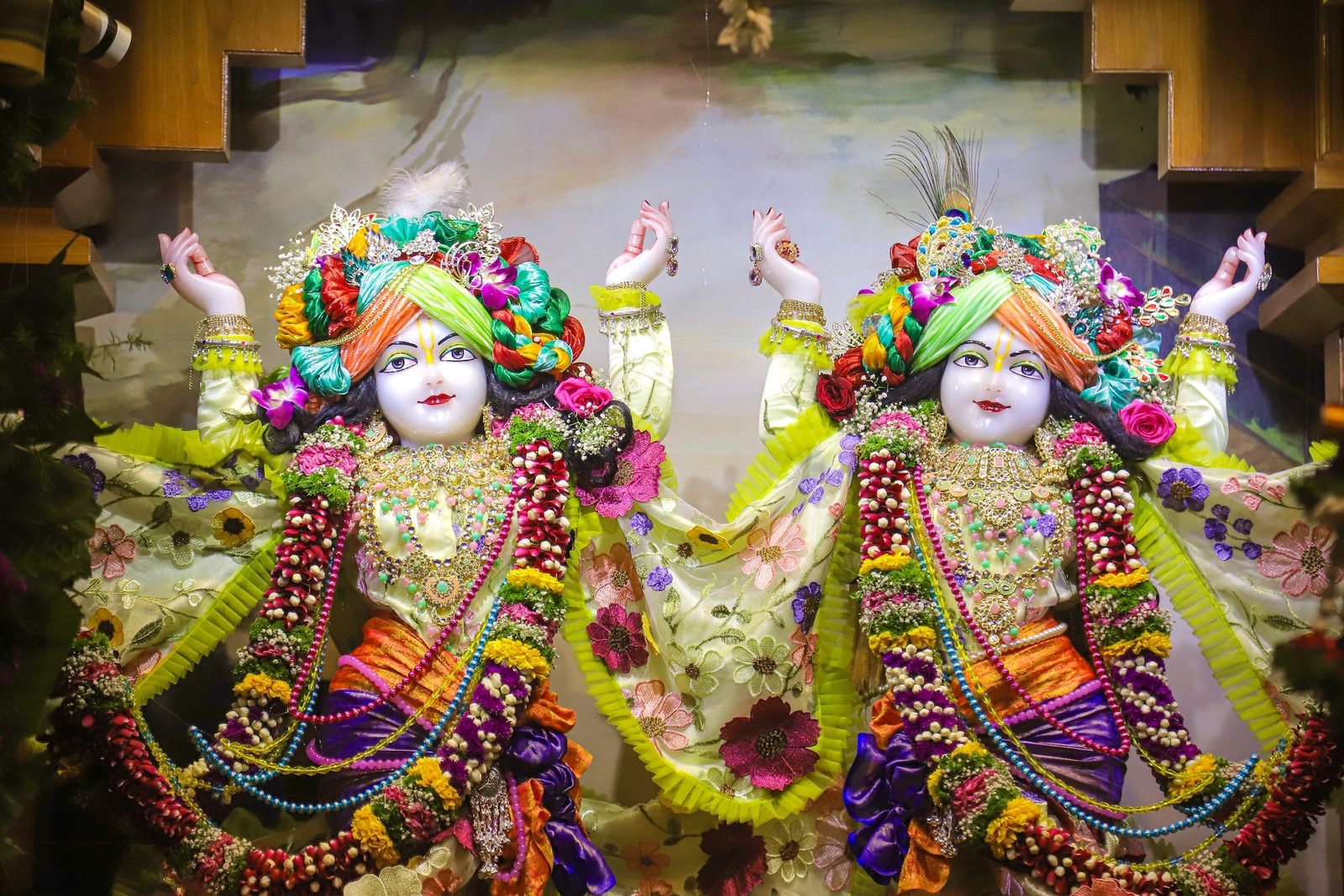 Sri Sri Gaura Nitai deities with arms raised in kirtan, beautifully dressed and garlanded with flowers at ISKCON Satara